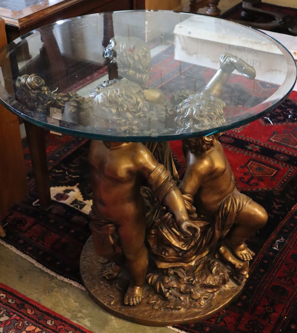 A cast gilt metal glass top cherub centre table, 81cm diameter